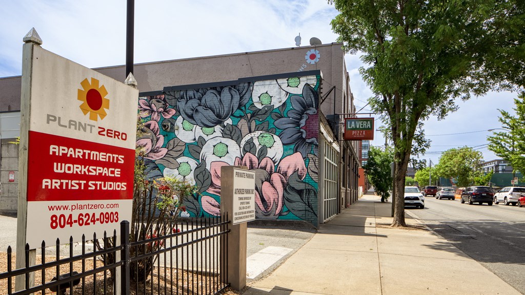 a mural of flowers on the side of a building with a fence