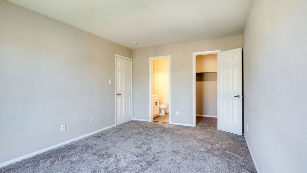 a living room with carpet and a door to a bedroom  at Bayville Apartments, Virginia Beach, 23455
