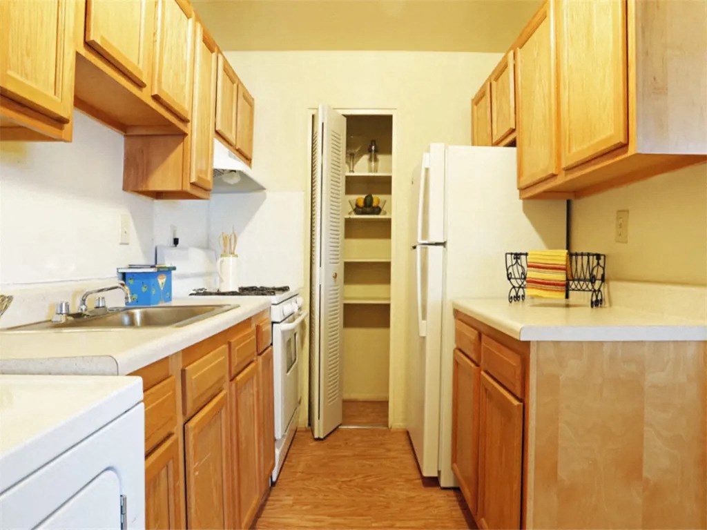 a kitchen with wooden cabinets and a white refrigerator at Gates of West Bay, Virginia
