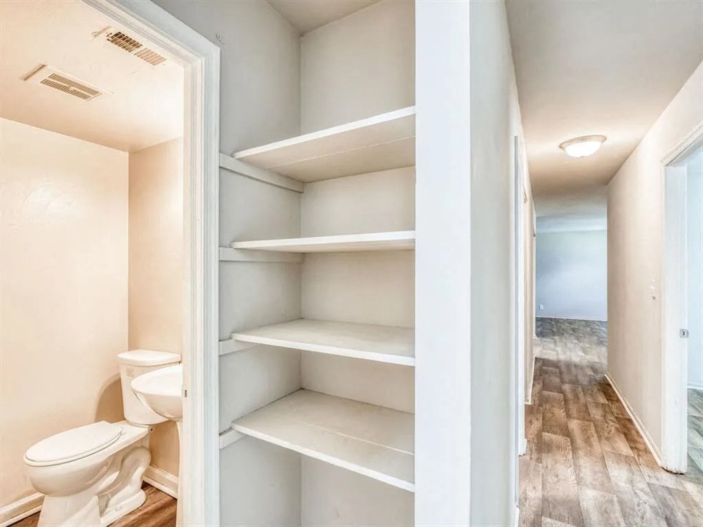 a bathroom with a toilet and some shelves in it at Gates of West Bay, Norfolk, VA 23503
