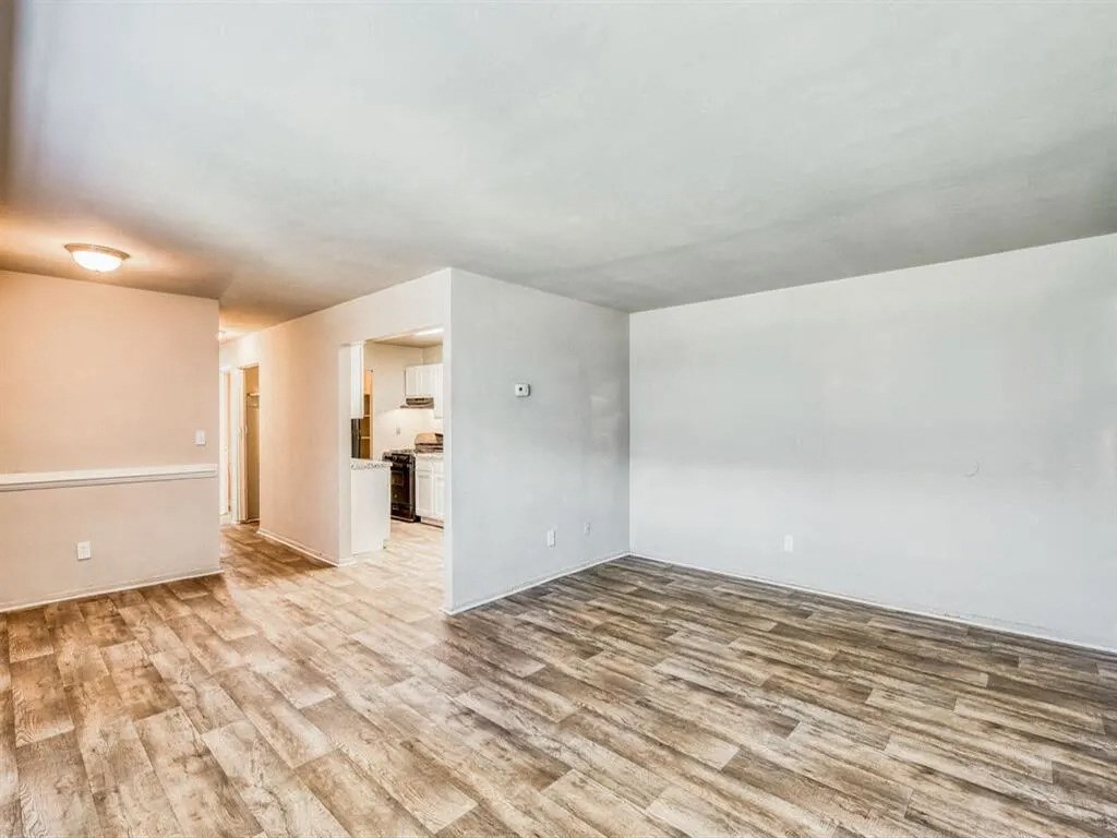an empty living room with white walls and wood flooring at Gates of West Bay, Virginia, 23503