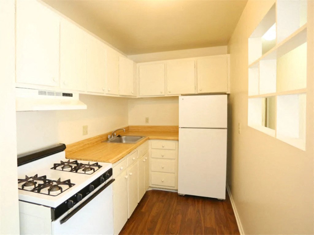 a kitchen with white appliances and white cabinets at Gates of West Bay, Norfolk 