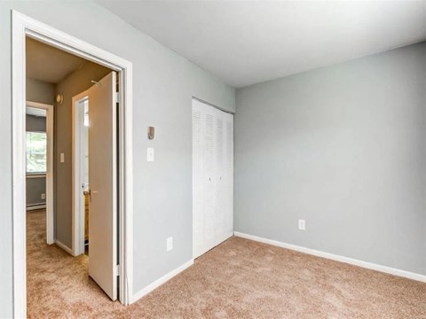 A room with a carpeted floor and a white door.