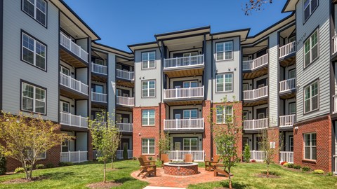 Apartment complex with a courtyard and trees.