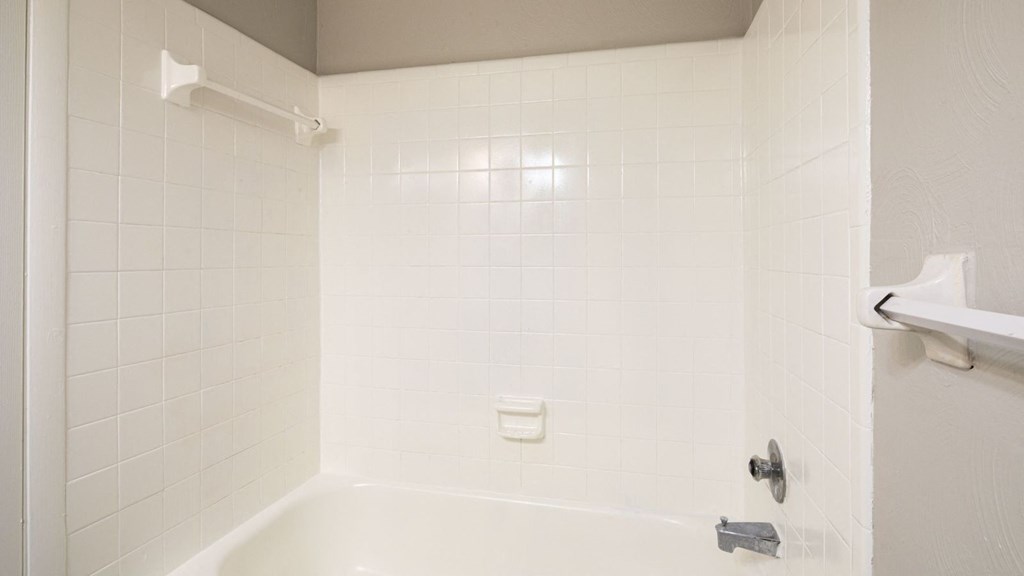 a white bathroom with a tub and a shower curtain at Bayville Apartments, Virginia, 23455