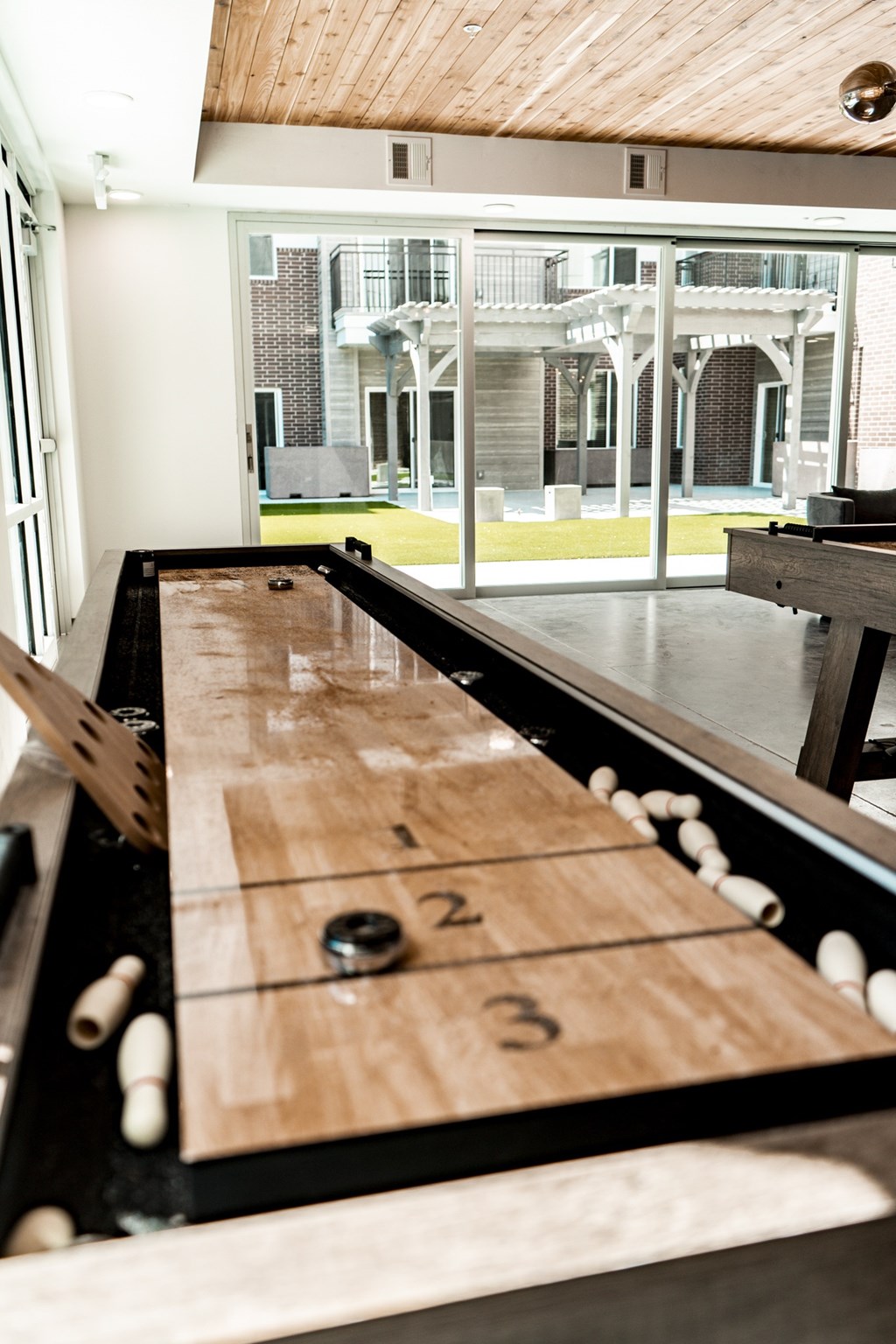 A shuffleboard table with numbers 2 and 3 on it.