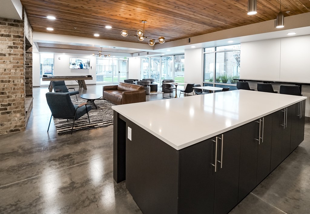A modern kitchen with a large island and black and white furniture.