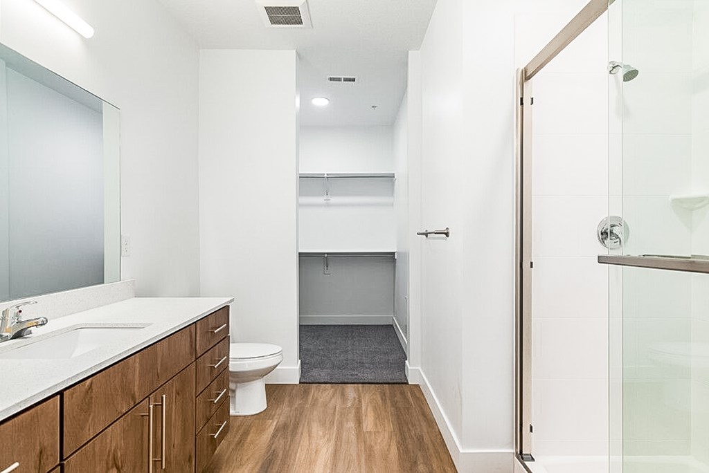 A white bathroom with a toilet, sink, and mirror.