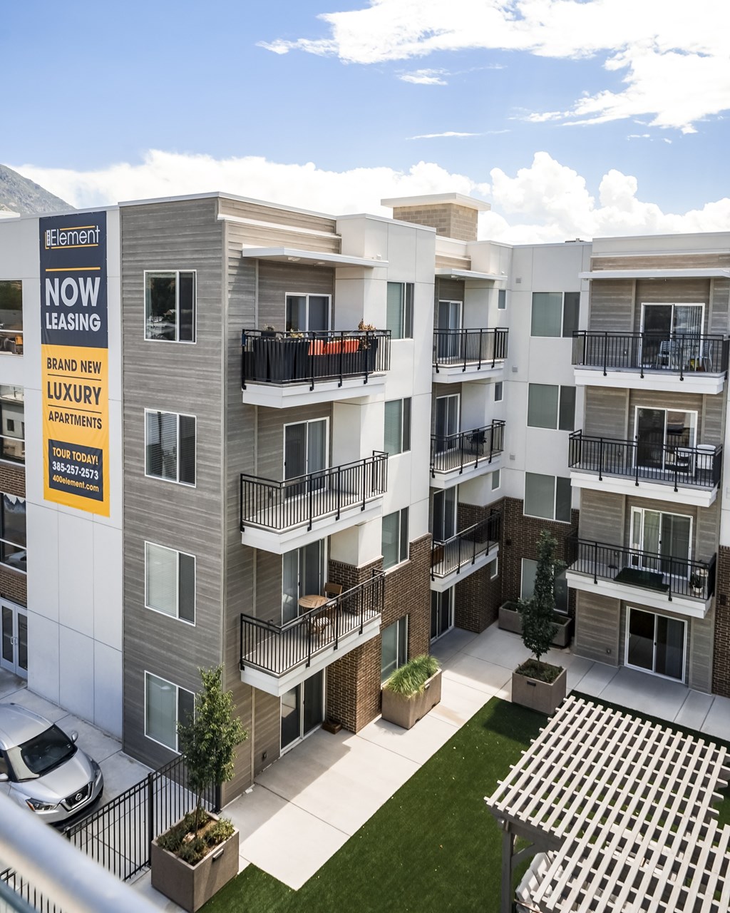 Apartment complex with a sign that says "Element Now Leasing.".