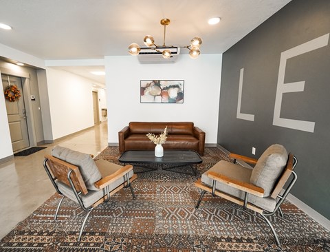 A living room with a brown couch and two chairs.