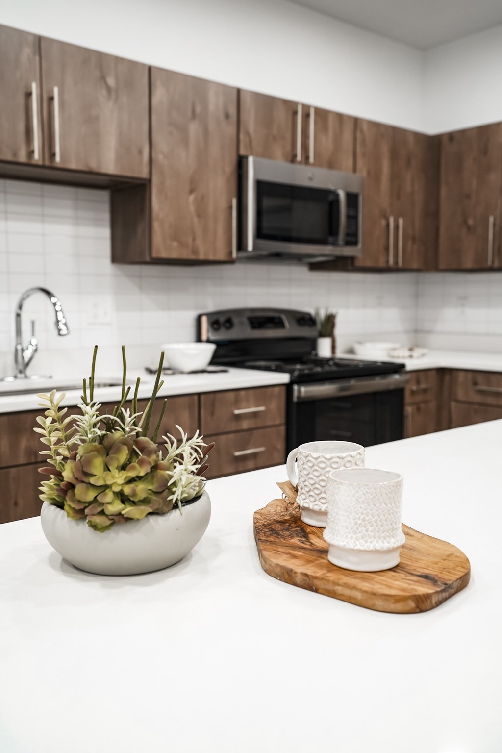 A kitchen with a white counter top and wooden cabinets.