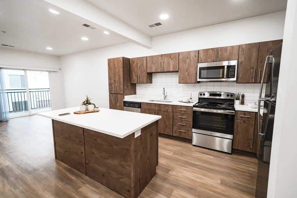 A modern kitchen with wooden cabinets and stainless steel appliances.