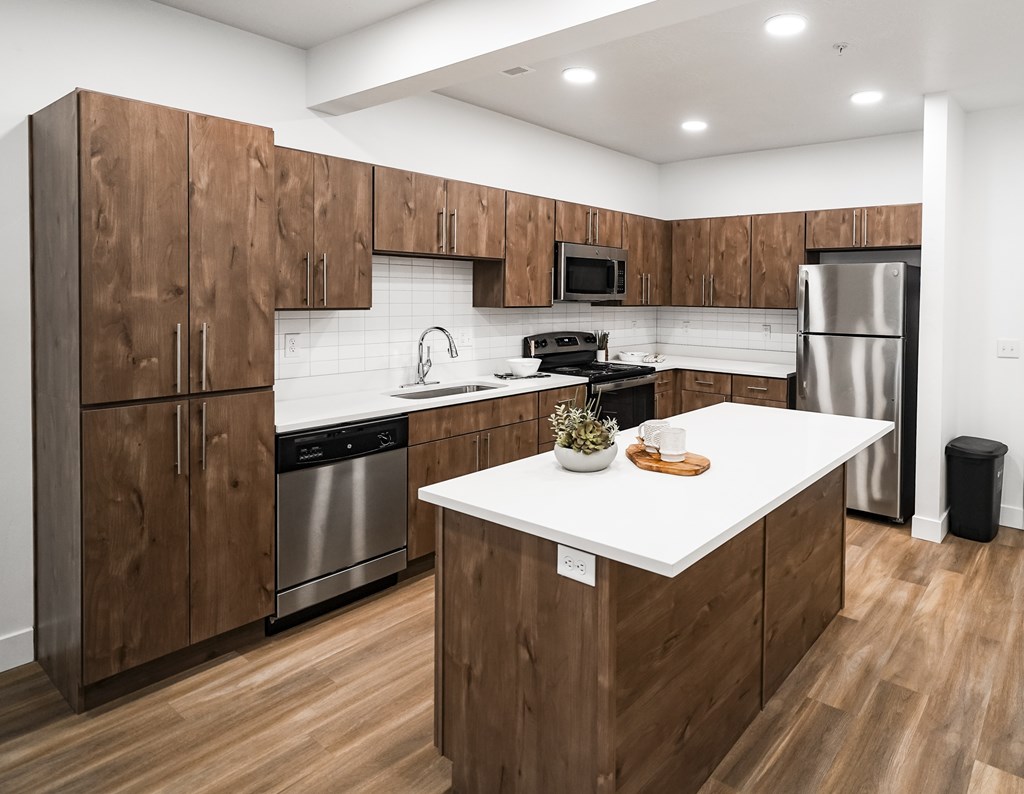 A kitchen with wooden cabinets and a white island.
