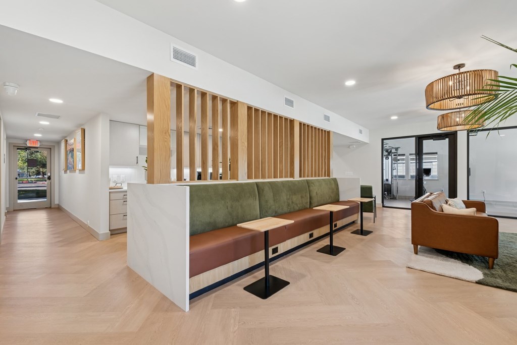 A long white reception desk with a green cushion on top.