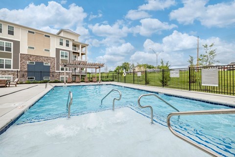 A pool with a slide and a building in the background.