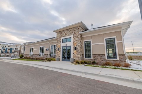 A building with a stone facade and a flat roof is shown.
