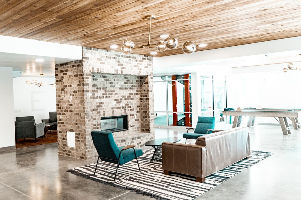A modern living room with a stone fireplace and a wooden ceiling.