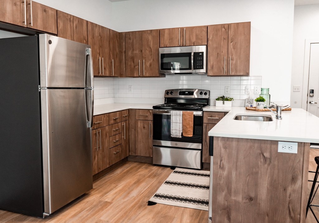 A modern kitchen with wooden cabinets and stainless steel appliances.