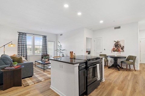 A modern kitchen with a black stove top oven and white cabinets.