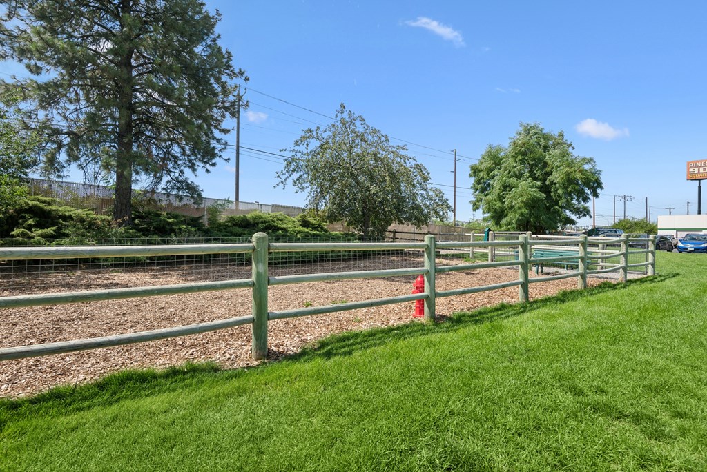A green fence with a red post in the middle.