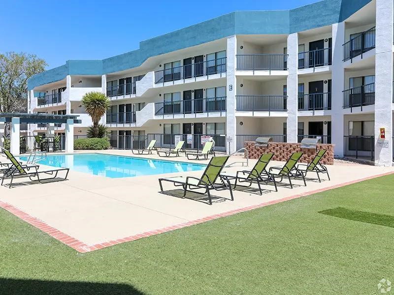 A large building with a pool in front of it.