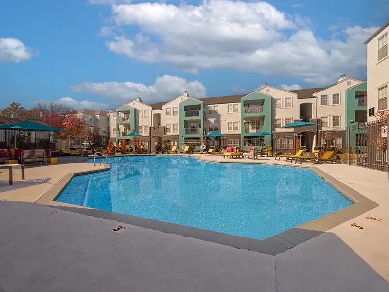 A large swimming pool in front of apartment buildings.