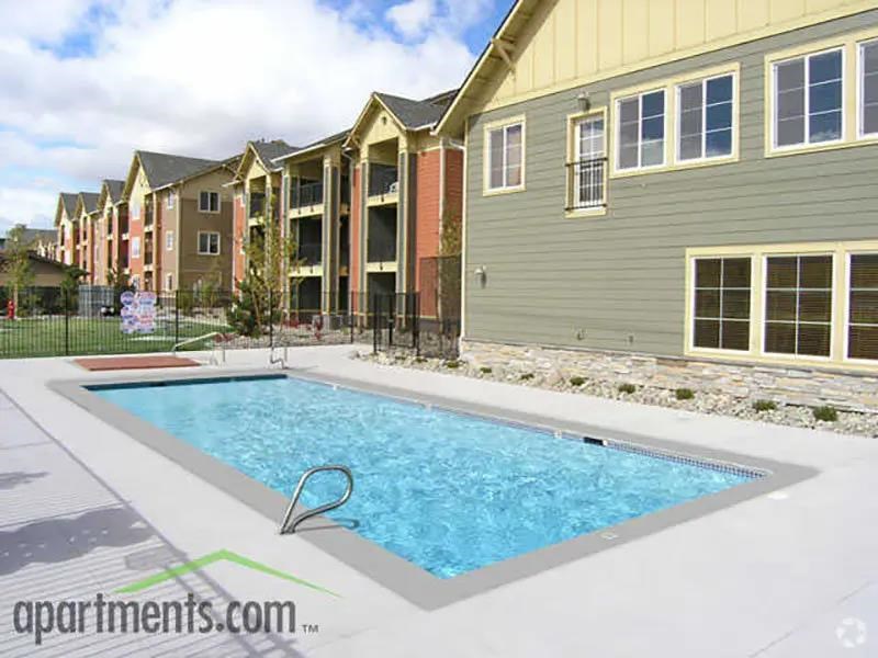 A swimming pool in front of apartment buildings.