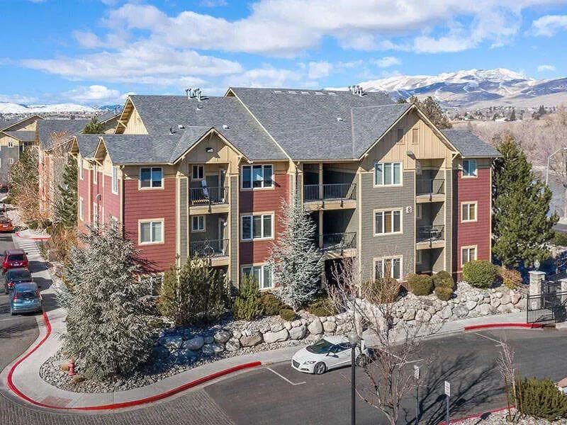 Apartment complex with a car parked in front.