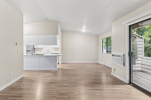 A kitchen with white cabinets and a wooden floor.