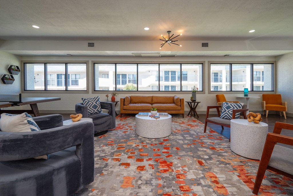 A living room with grey and orange carpet.