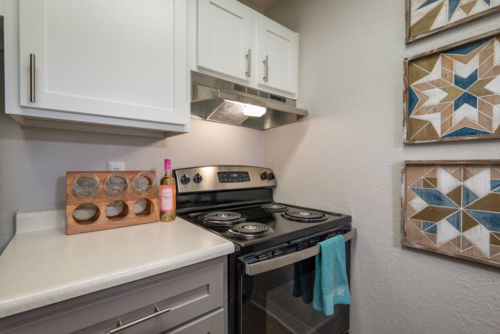 A kitchen with a stove top oven and a tile backsplash.
