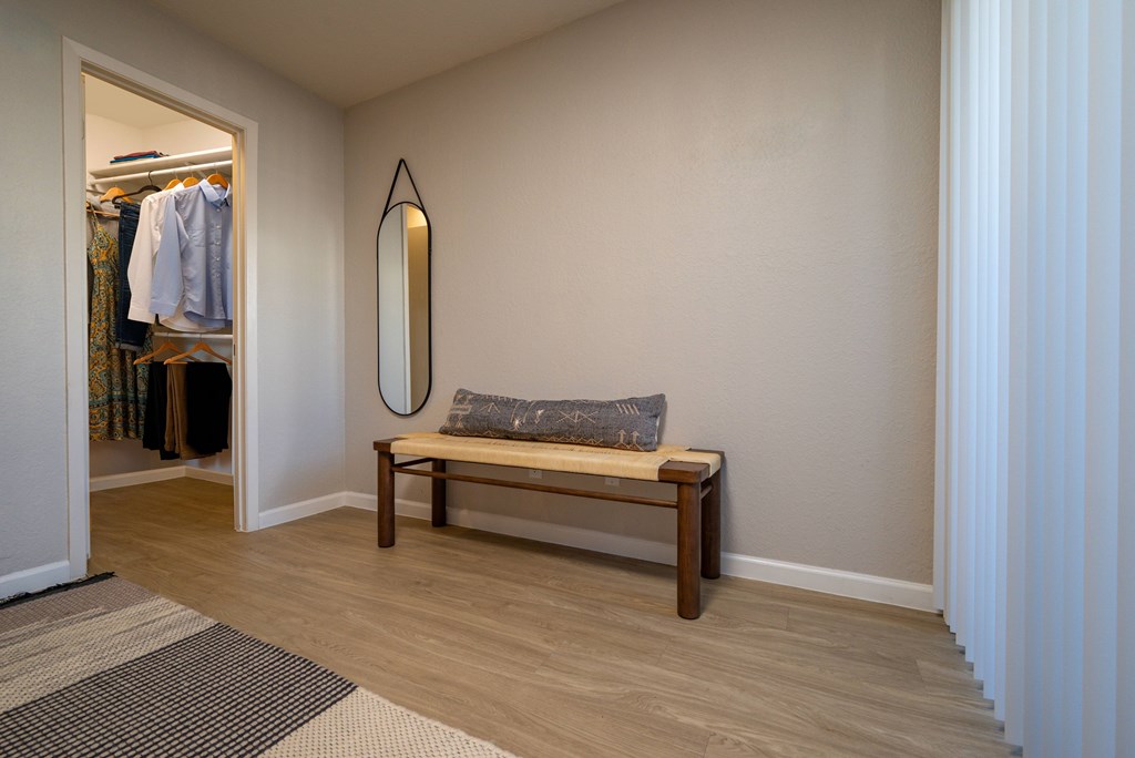 A room with a bench and a mirror.