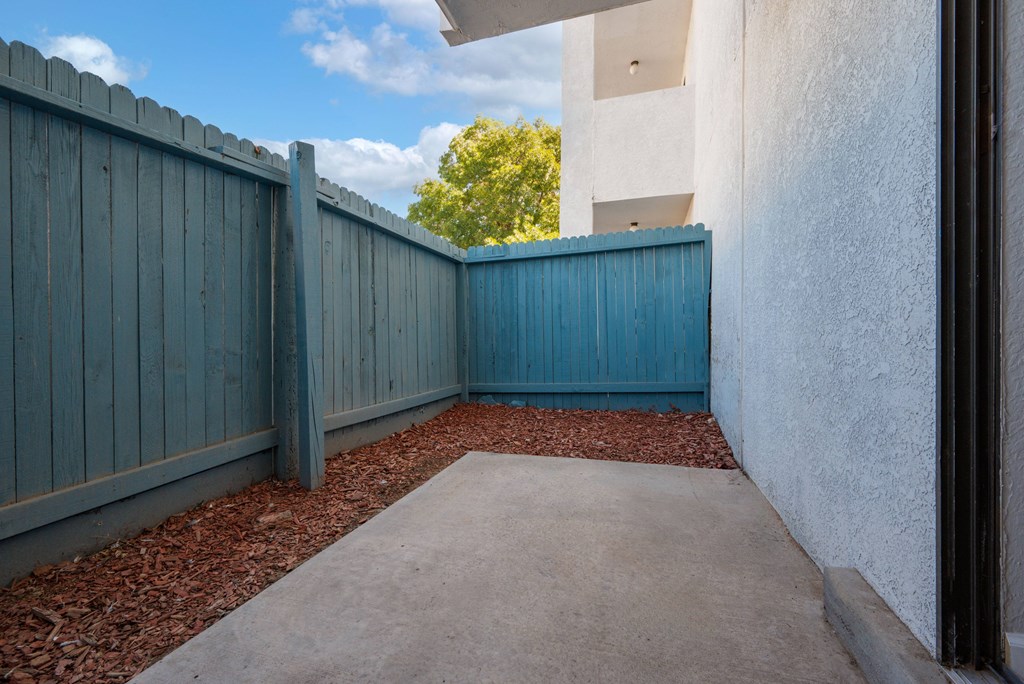 A concrete pathway leads to a blue fence.