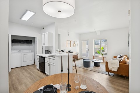 A modern kitchen with a dining table set for two.