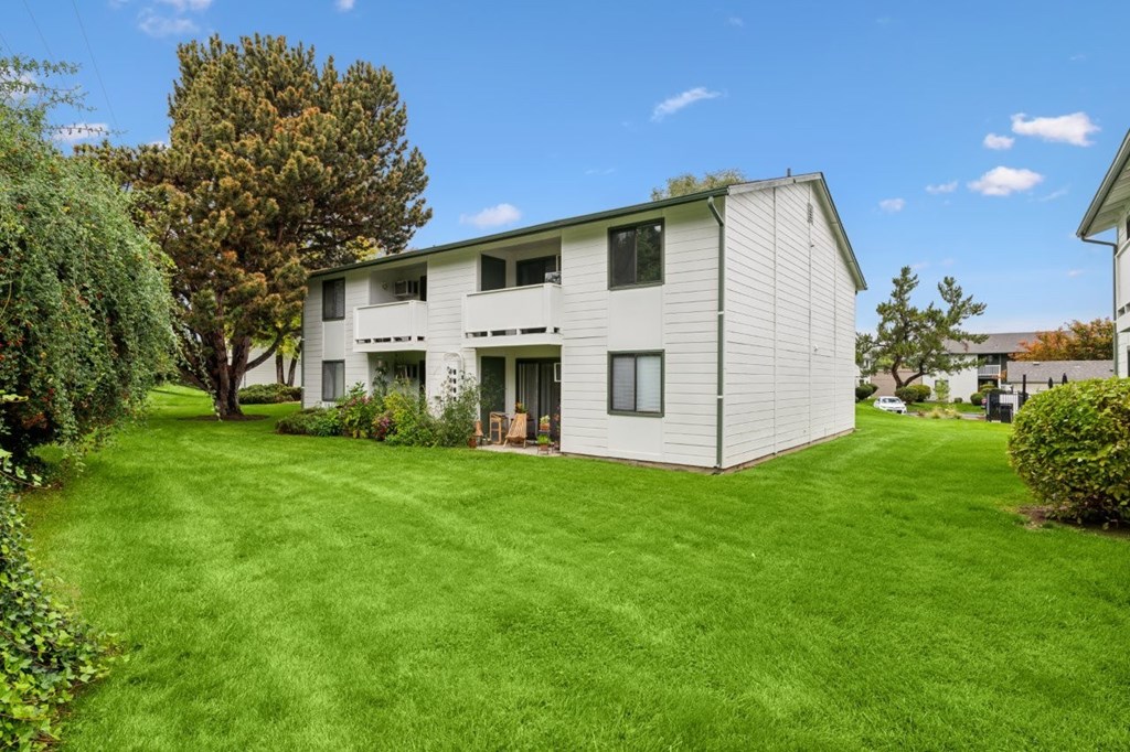 A white house with a green lawn in front.