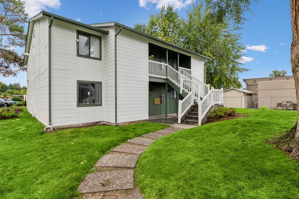 A small white house with a green door and a porch.