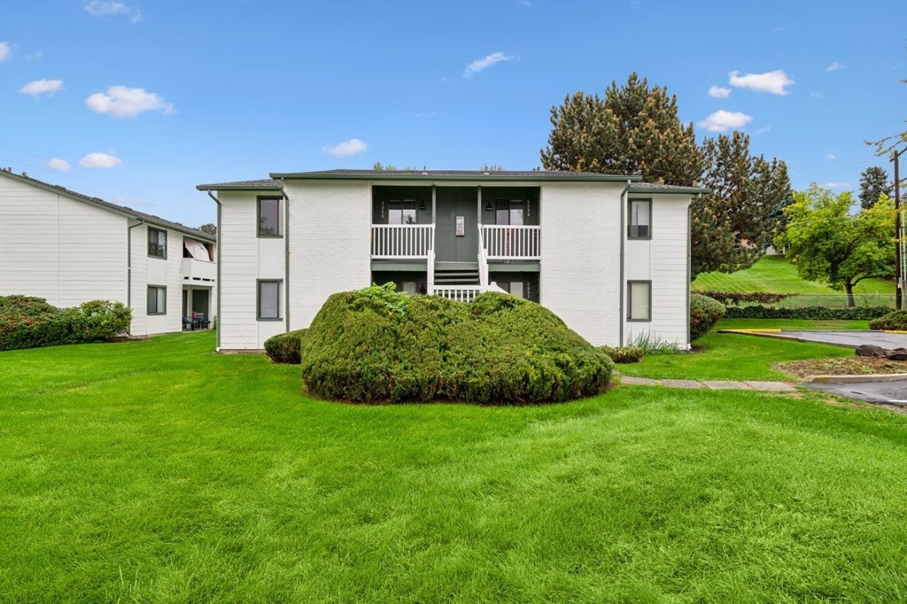 A large grassy area in front of a two story building.