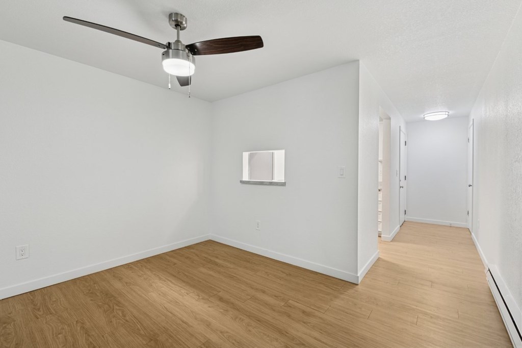 A room with a ceiling fan and a picture frame on the wall.