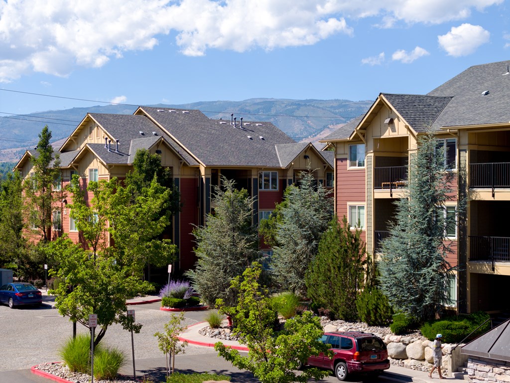 A row of houses with trees in front of them.