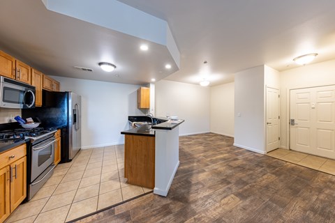 A kitchen with wooden cabinets and a black refrigerator.