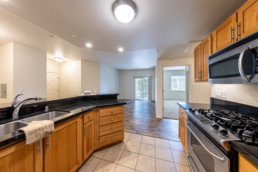 A kitchen with wooden cabinets and a black stove top.
