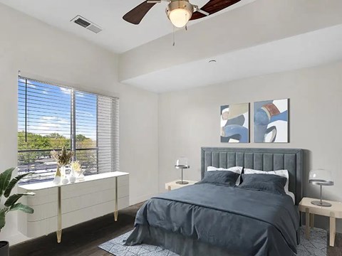 A bedroom with a bed, nightstands, and a ceiling fan.