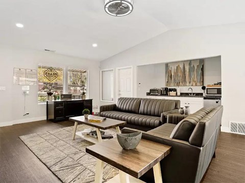 A modern living room with a brown leather couch and a wooden coffee table.