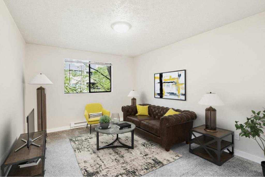 A living room with a brown couch, yellow chair, and a rug.
