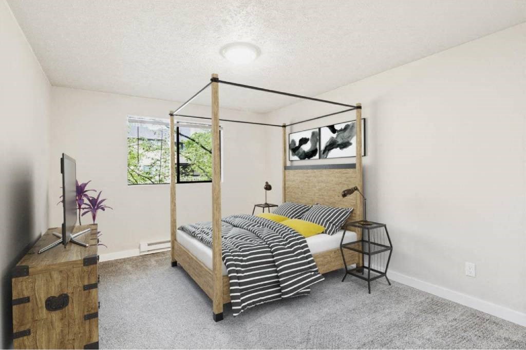 A bedroom with a four poster bed and a wooden dresser.