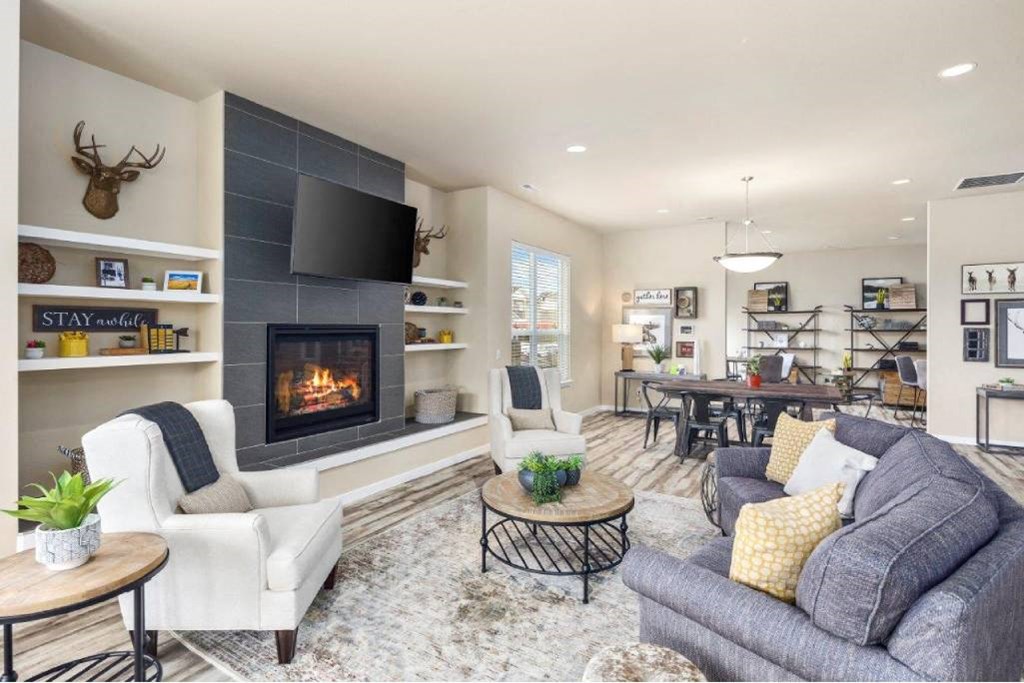 A living room with a fireplace and a television on the wall.