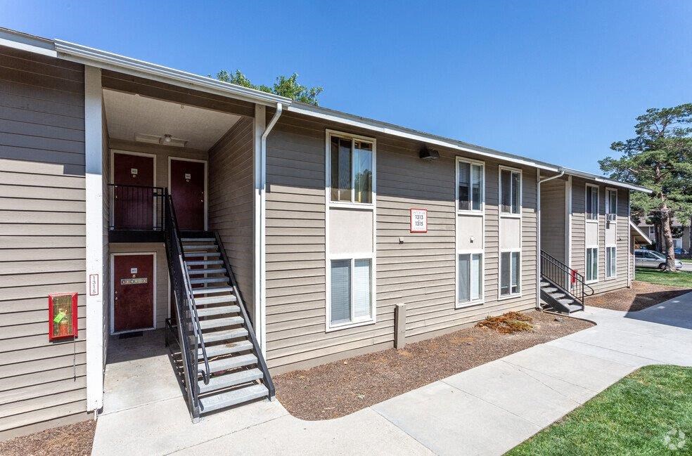 A building with a red door and a staircase leading to the entrance.