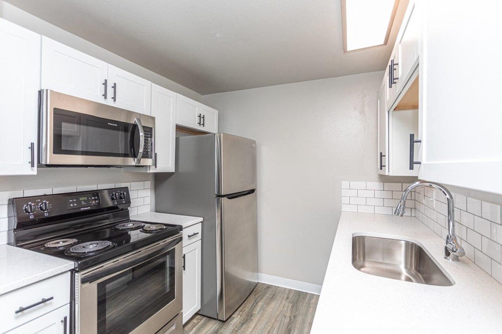 A kitchen with white cabinets and stainless steel appliances.