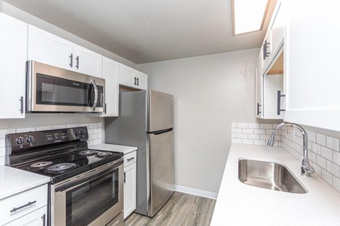 A kitchen with white cabinets and stainless steel appliances.