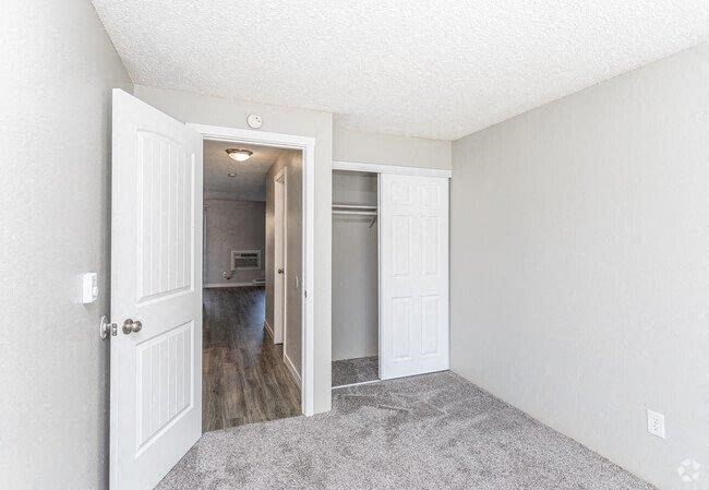 A room with a white door and a carpeted floor.